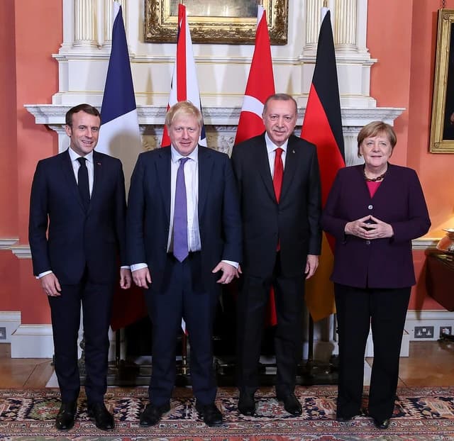 Emmanuel Macron, Boris Johnson, Recep Tayyip Erdoğan, and Angela Merkel posing for a group photo.