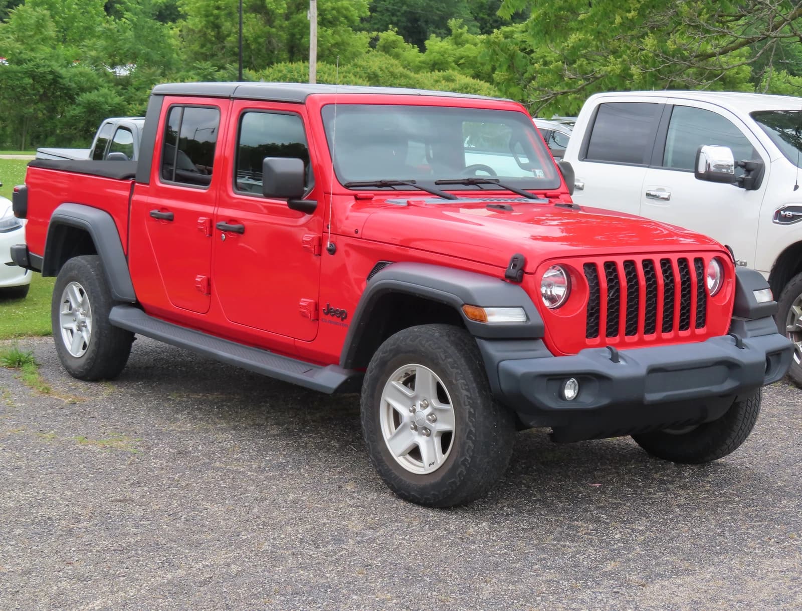Red 2020 Jeep Gladiator Sport S pickup truck, front right view, parked outdoors.