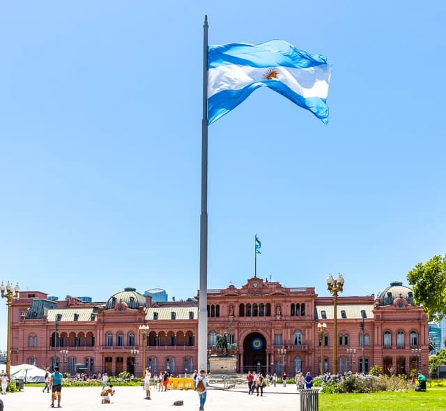 The Casa Rosada, a pink building with an Argentine flag flying prominently in front.