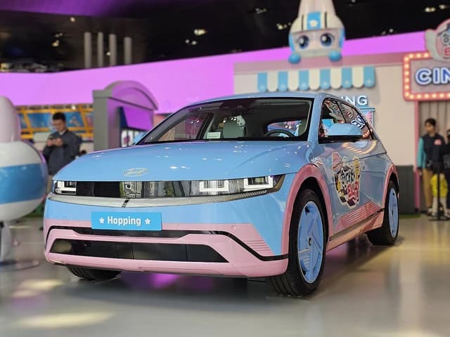 Hyundai Ioniq 5 electric car in blue and pink, parked indoors.