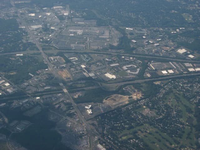 Aerial view shows Moorestown Mall and surrounding areas, including roads and buildings.