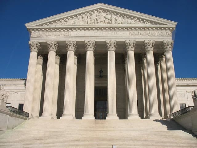Exterior facade of the US Supreme Court building with grand columns and stairs.