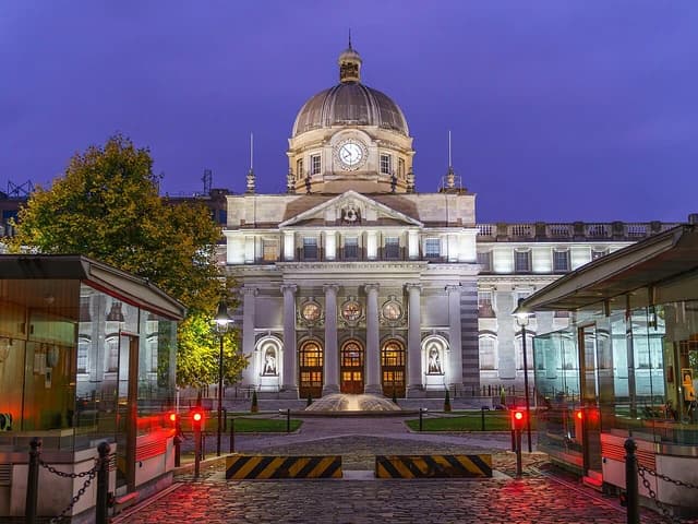 Government Buildings in Merrion Square, Dublin, illuminated at dusk with a purple sky.