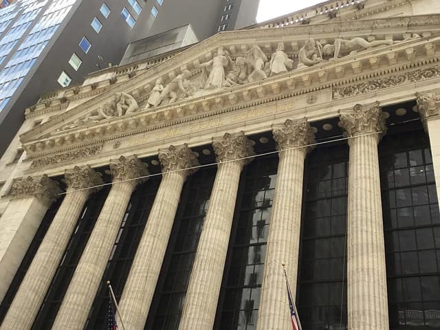 Exterior of the New York Stock Exchange building with classical columns and pediment sculptures.