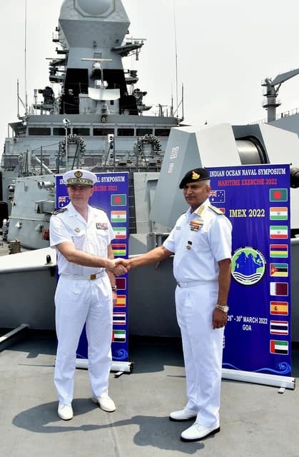 Admiral R Hari Kumar and Admiral Pierre Vandier shake hands on a ship.