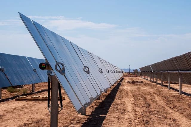 Solar panels installed at a construction site in a desert landscape.
