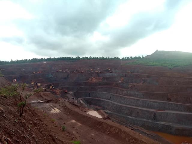 Serajuddin iron ore mines, a large-scale open-pit mining operation, under an overcast sky.