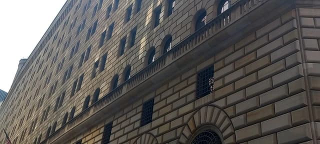 Federal Reserve Bank of New York building exterior, showing many windows and stone facade.