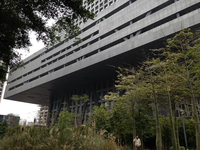The modern architecture of the Shenzhen Stock Exchange building seen from a street level.