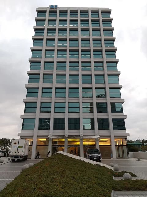 A modern, multi-story building with a sign that reads 'AI' at its top.