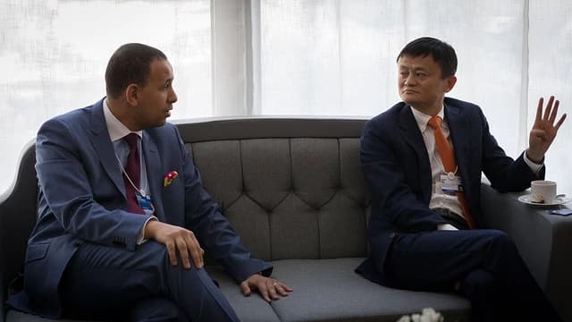 Jack Ma, co-founder of Alibaba, speaking to another individual on a sofa.