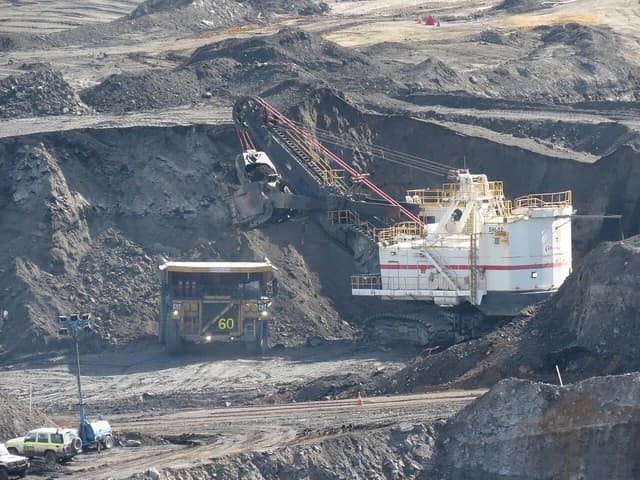 Heavy mining machinery, including a large excavator and haul truck, at the Premier coal mine.