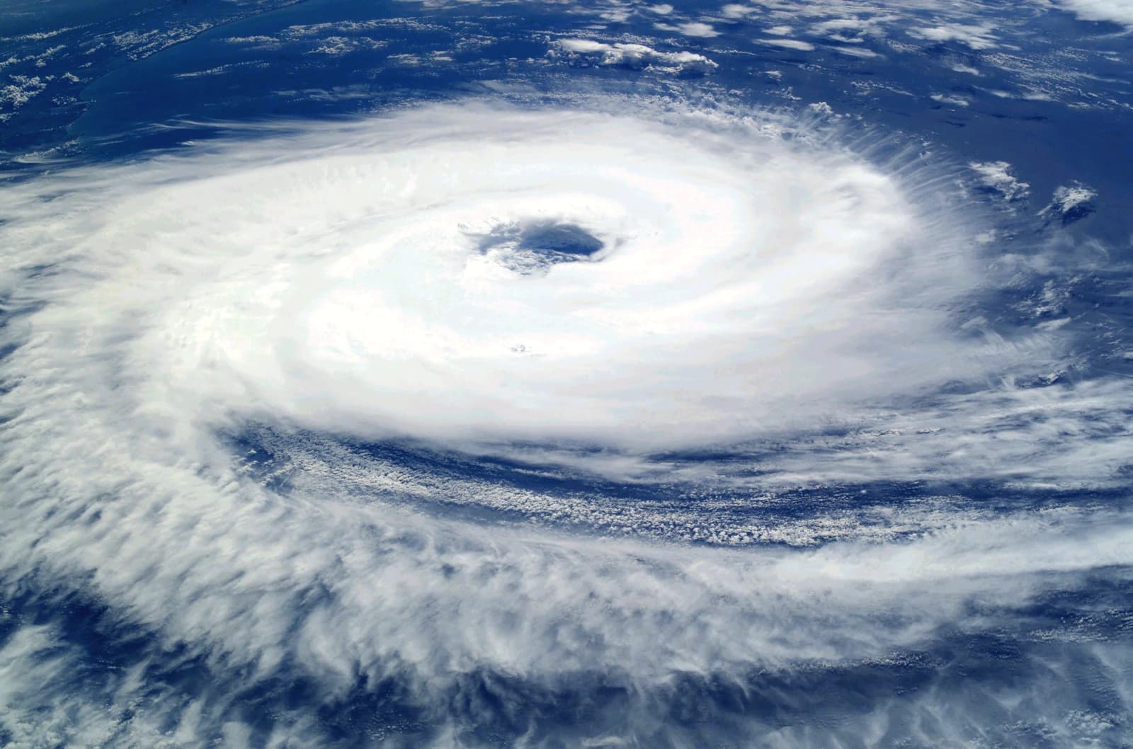 Satellite image of a massive spiral cloud formation, indicating a strong cyclone over open water.