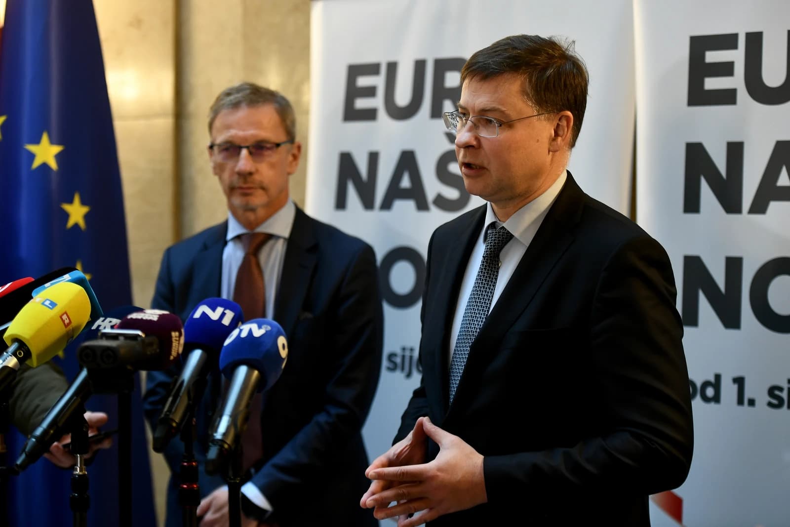 Valdis Dombrovskis, Executive Vice-President of the European Commission, speaking at a podium with microphones.