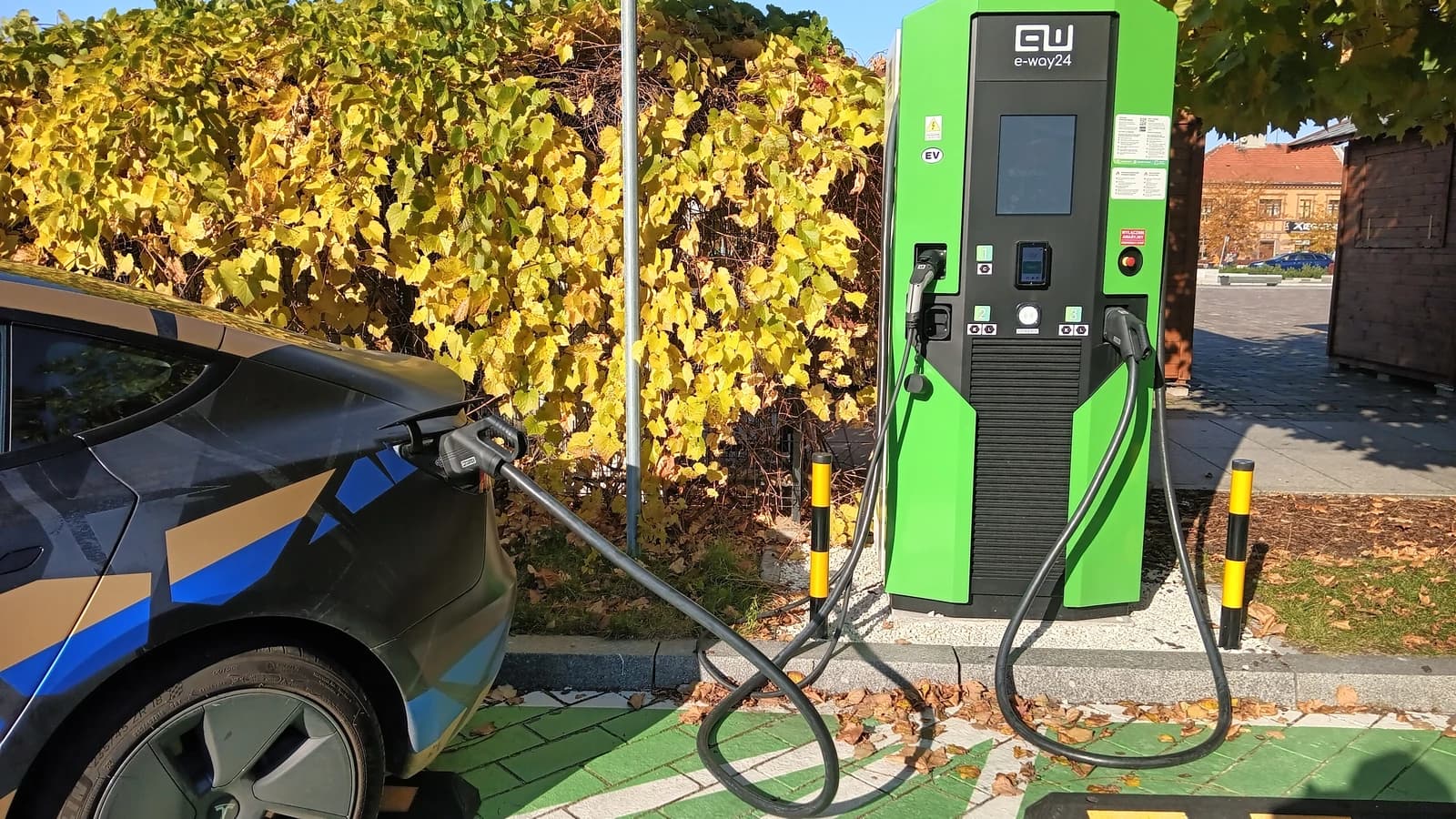 Tesla Model 3 electric car charging at a green e-way24 charging station.