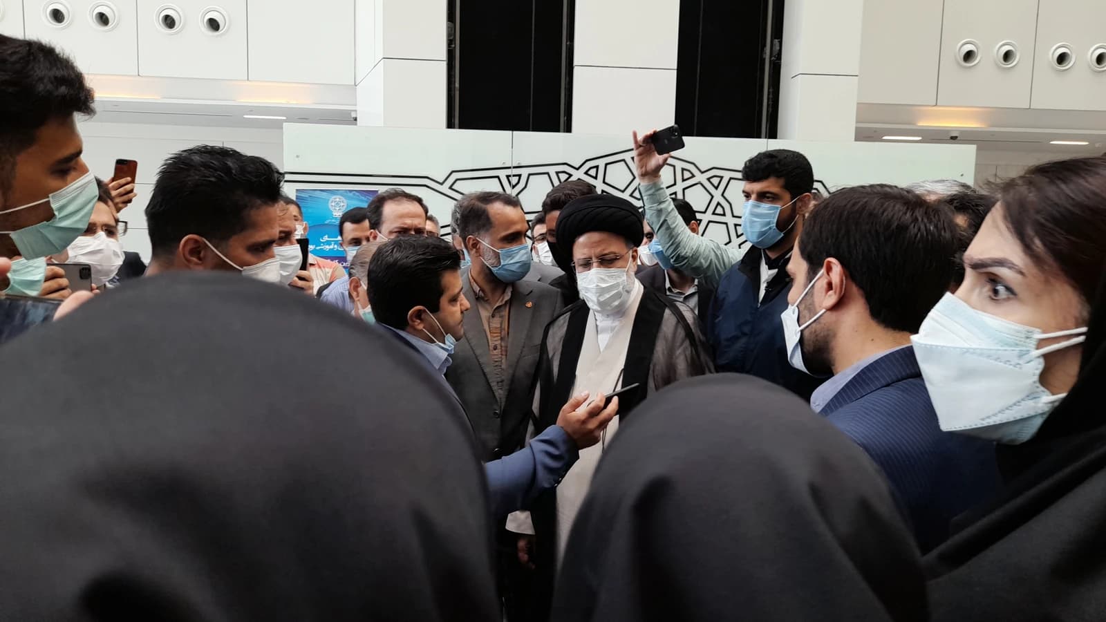 Ebrahim Raisi, then Judiciary Chief, is surrounded by people during a visit to the Tehran Stock Exchange.