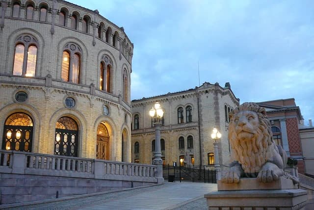 Exterior view of the Norwegian Parliament building in Oslo at dusk.