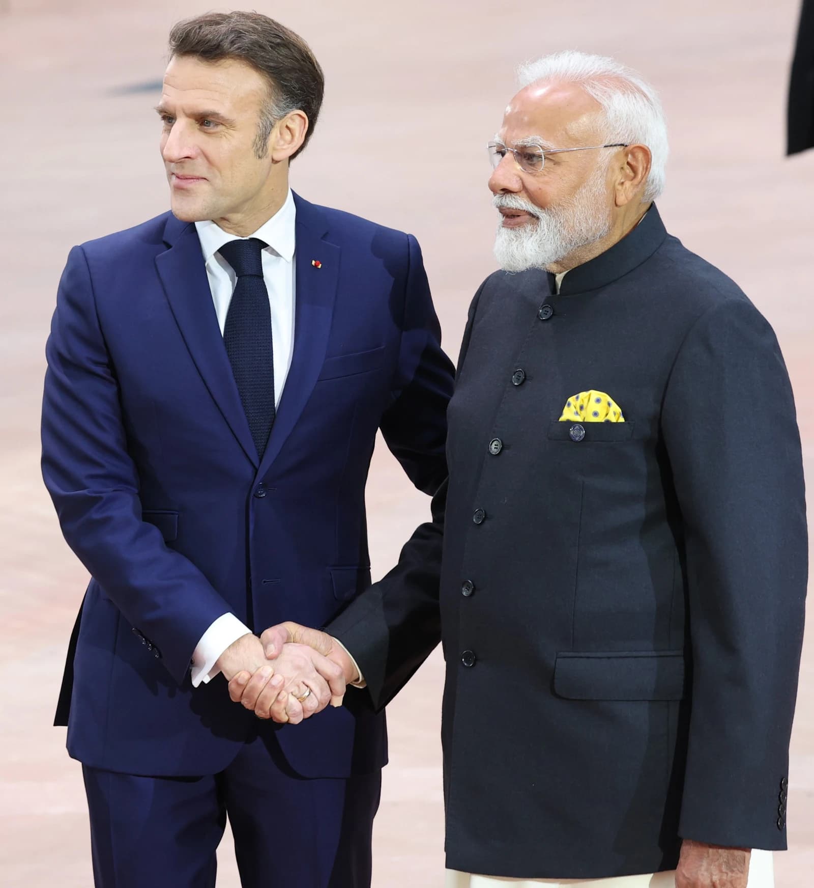 President Emmanuel Macron and Prime Minister Narendra Modi shake hands at a summit.