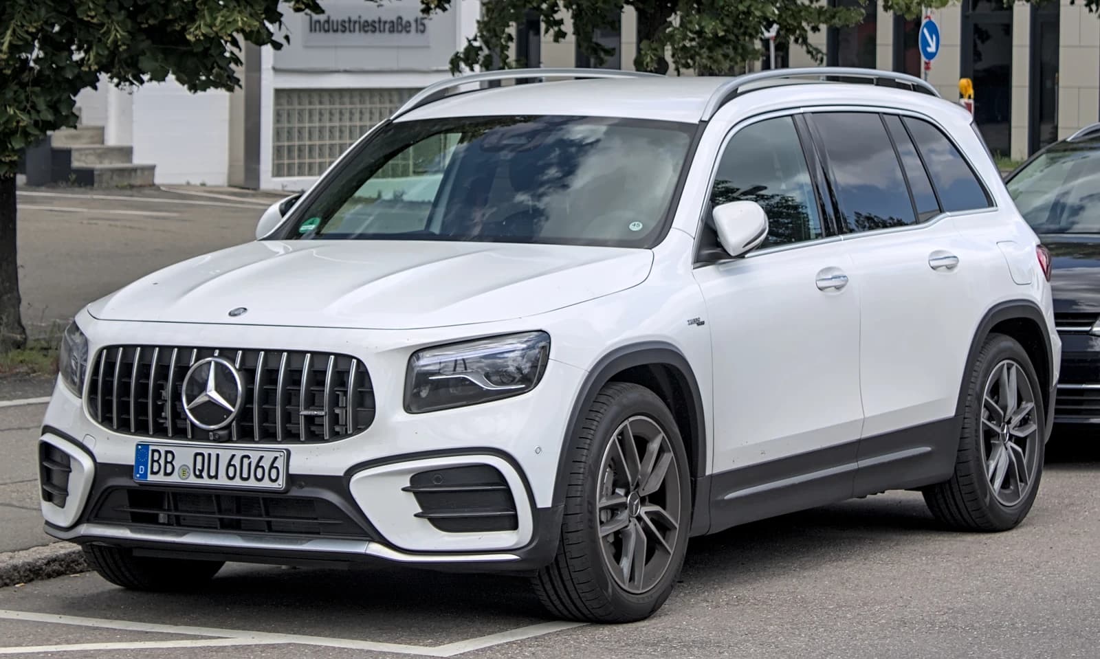 White Mercedes-AMG GLB 35 4MATIC SUV, seen from the front three-quarters angle, parked on a city street.