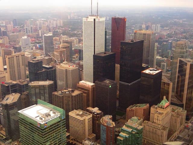 Aerial view of downtown Toronto, Ontario, with many tall buildings under a hazy sky.