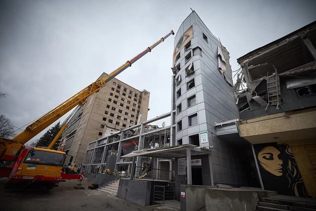 Damaged buildings in Zaporizhzhia, Ukraine, after a missile strike with a crane operating.