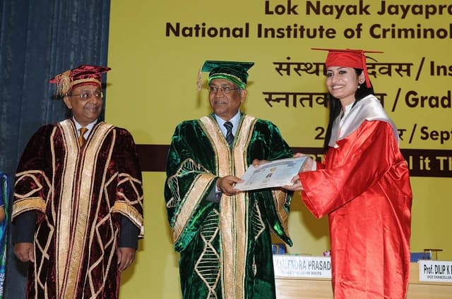 Prof. Dilip K. Bandyopadhyay presenting a degree to a graduate at a ceremony.