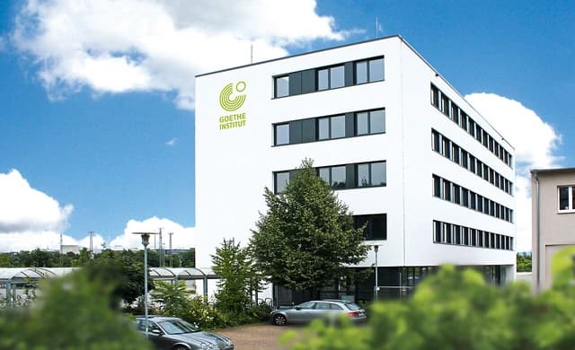 Exterior of the Goethe-Institut building in Mannheim, Germany, with cars parked outside.