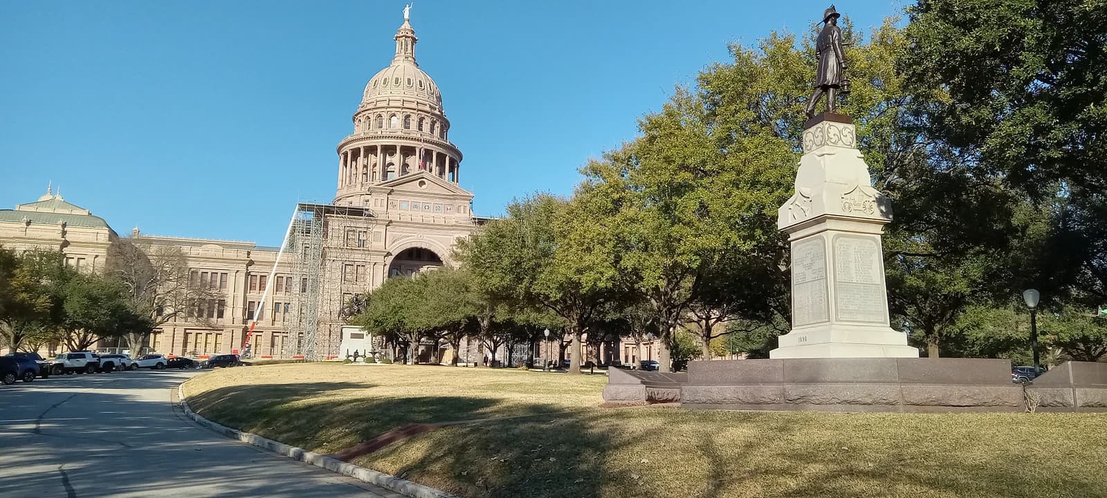 Texas State Capitol building in Austin with a monument in the foreground.