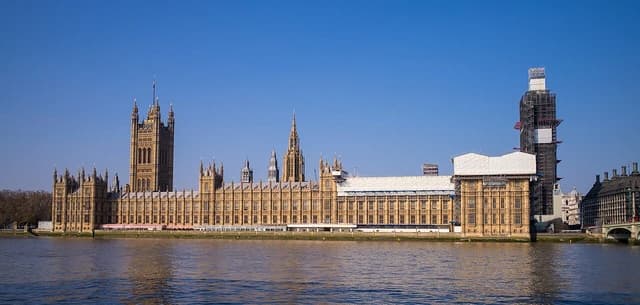 Houses of Parliament in London seen from across the River Thames on a clear day.