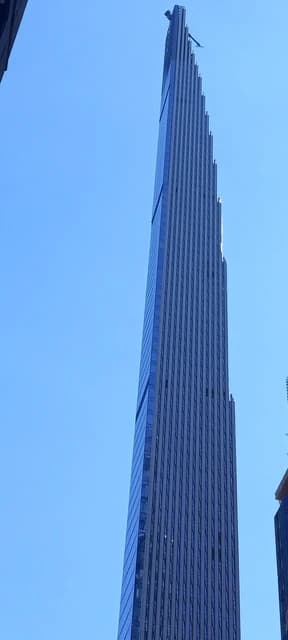 The supertall skyscraper 111 West 57th Street, known as the Steinway Tower, against a blue sky.