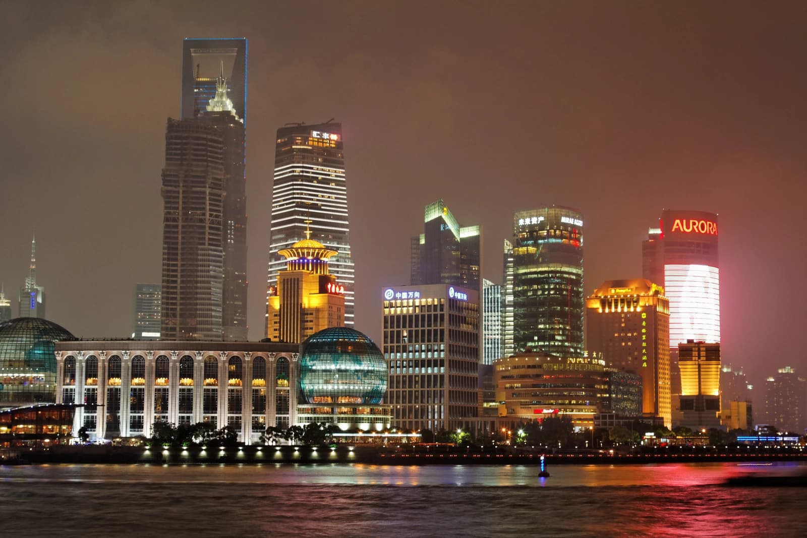 Night scene of illuminated skyscrapers in Lujiazui financial district, with the Jin Mao Tower and Shanghai World Financial Center visible.