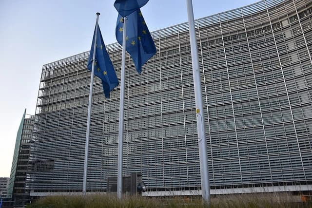 European Union flags flying in front of the European Commission building in Brussels.