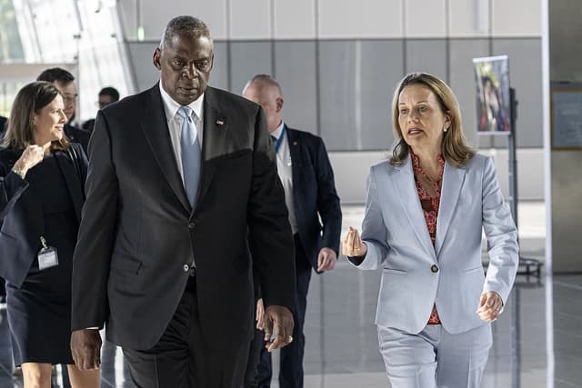 United States Secretary of Defense Lloyd Austin walking with U.S. Permanent Representative to NATO Ambassador Julianne Smith.