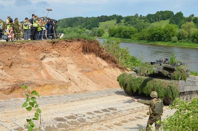 A German Army soldier directs a military vehicle onto land during combined exercises in Lithuania.