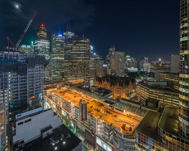 Night view of the Toronto skyline featuring numerous illuminated skyscrapers and city lights.