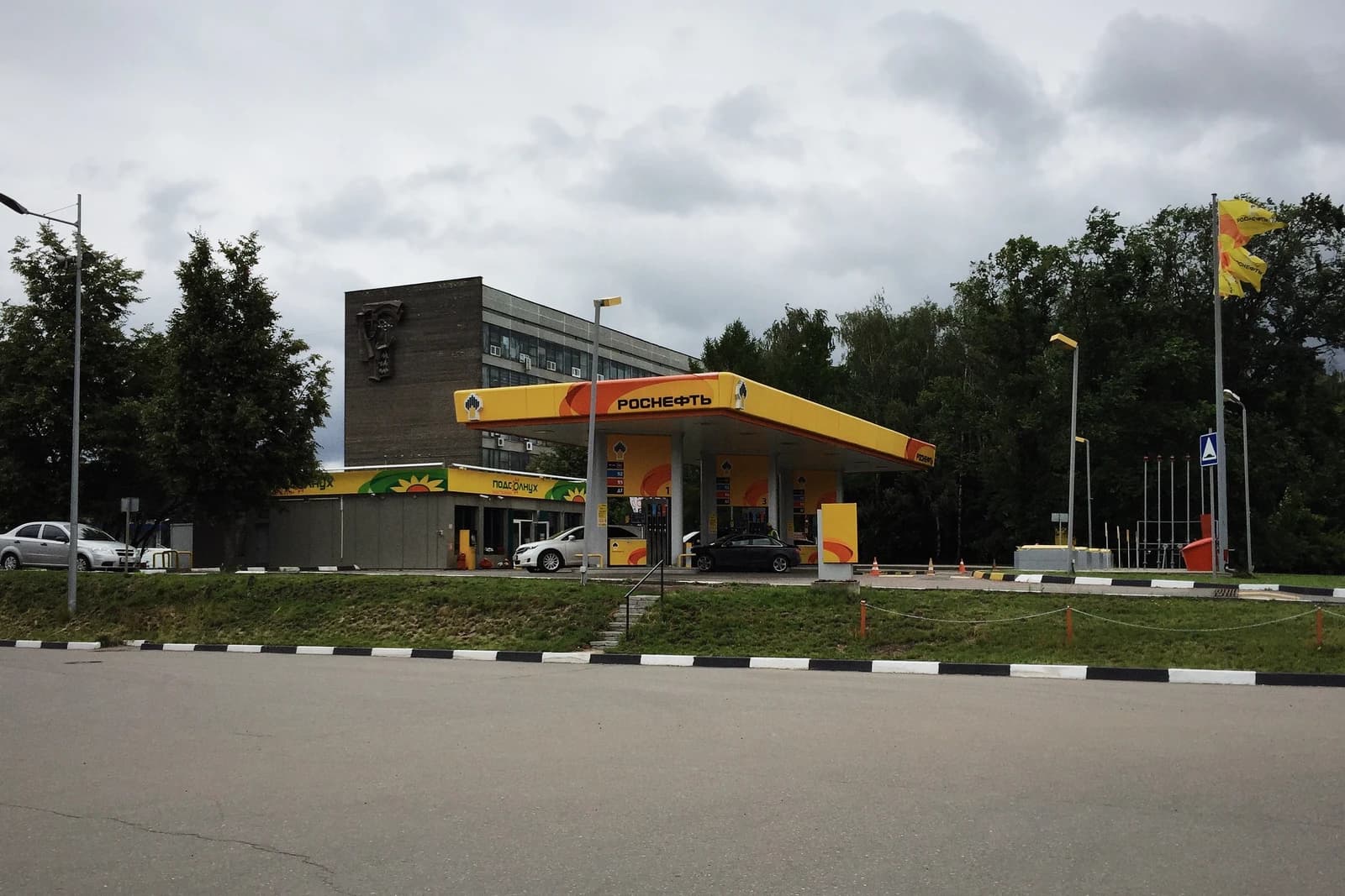 Rosneft petrol station with several cars parked under the canopy.