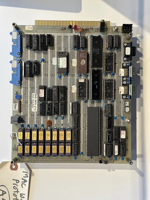 Close-up of an early Macintosh computer prototype circuit board with various chips and components.