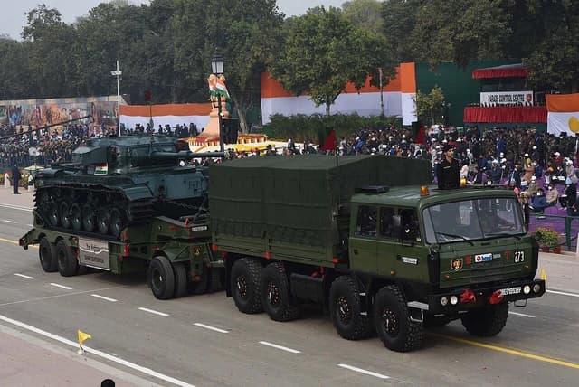 An Indian Army Centurion tank being transported on a heavy vehicle during a parade.