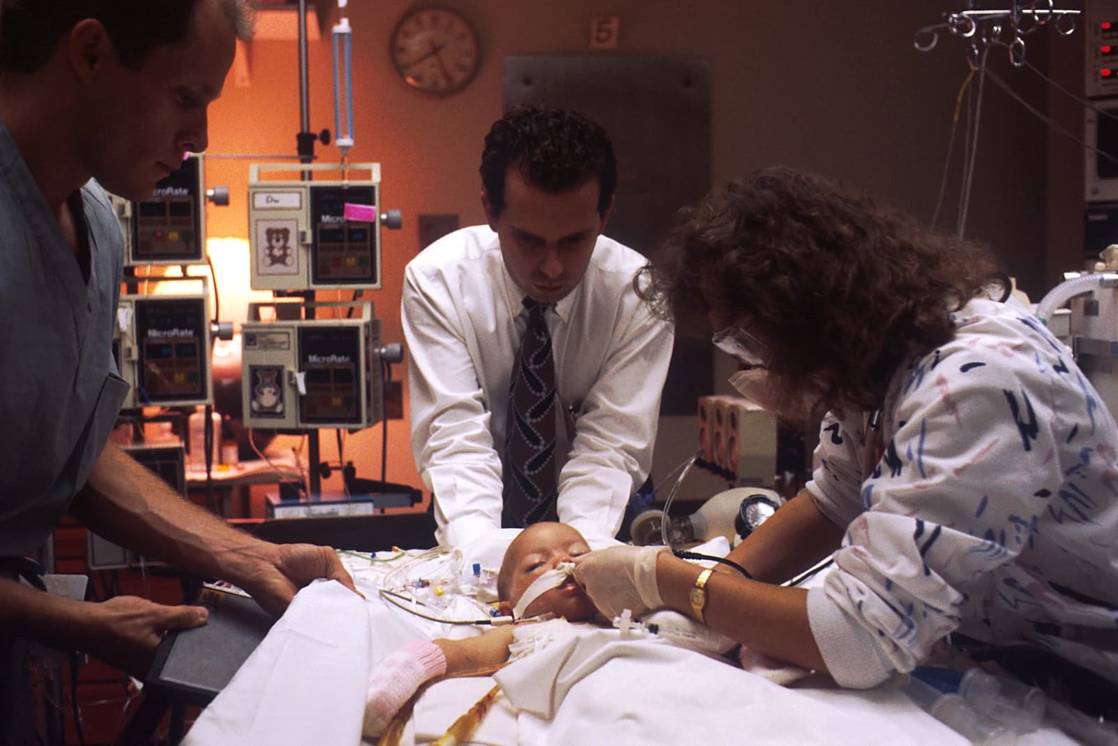 Medical personnel, a doctor and a nurse, treat an infant patient in an ICU.