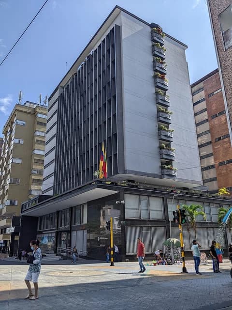 Banco de la República building in Ibagué, Colombia, with people walking outside.