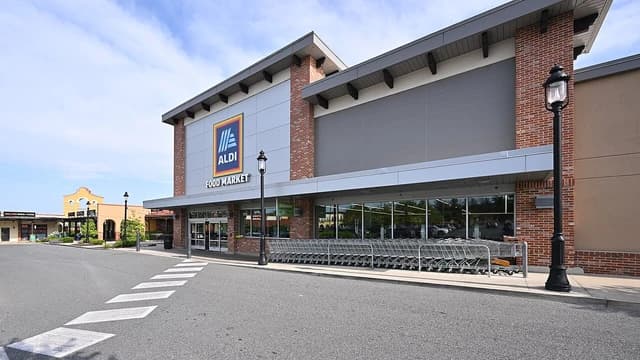 Exterior of an Aldi Food Market with shopping carts lined up outside.