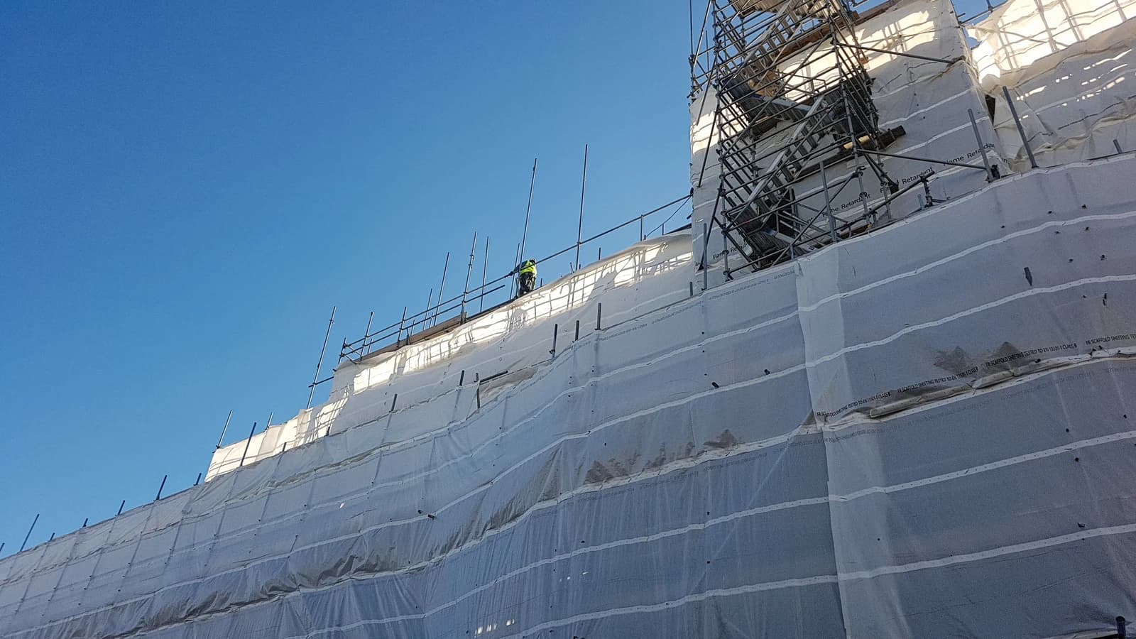 Construction scaffolding with protective white covering on a building in Tottenham, London.