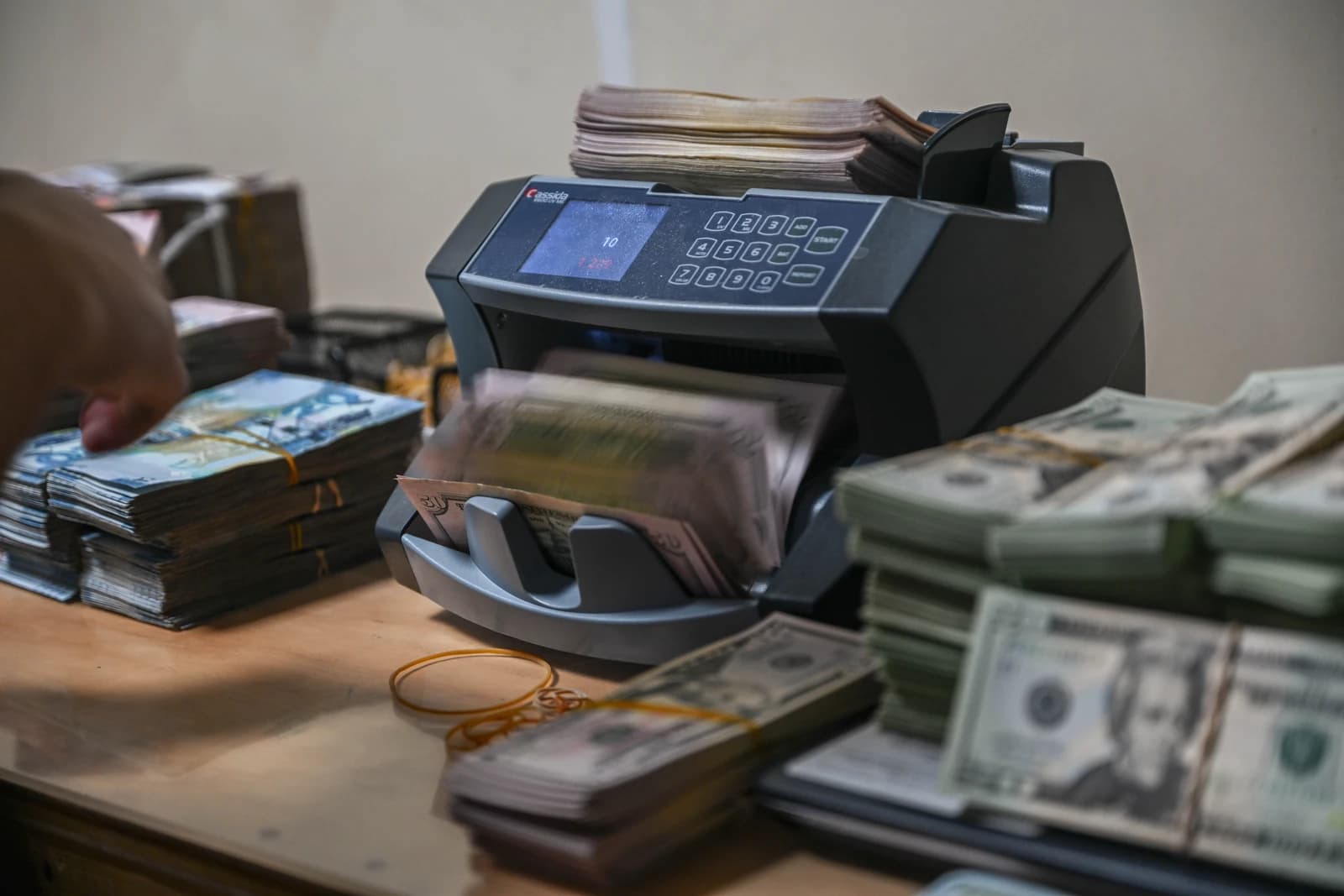 An airman from 386th AEW Financial Management flight counts money using a machine.