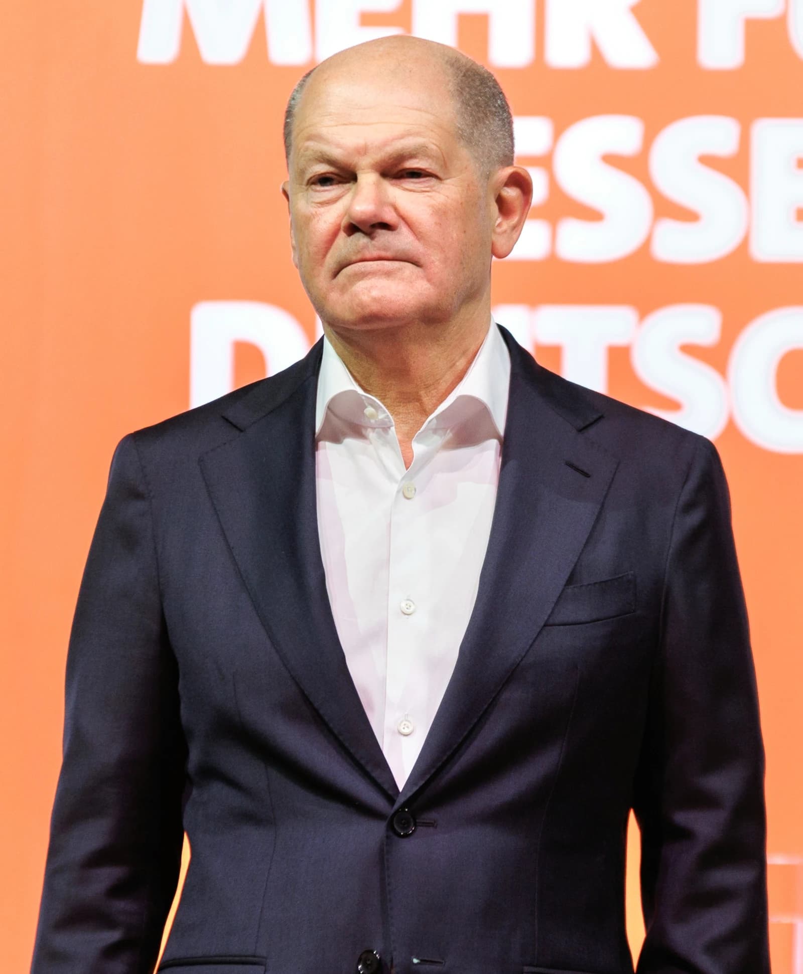Olaf Scholz, SPD-Kanzlerkandidat, stands in Erfurt with an orange background.