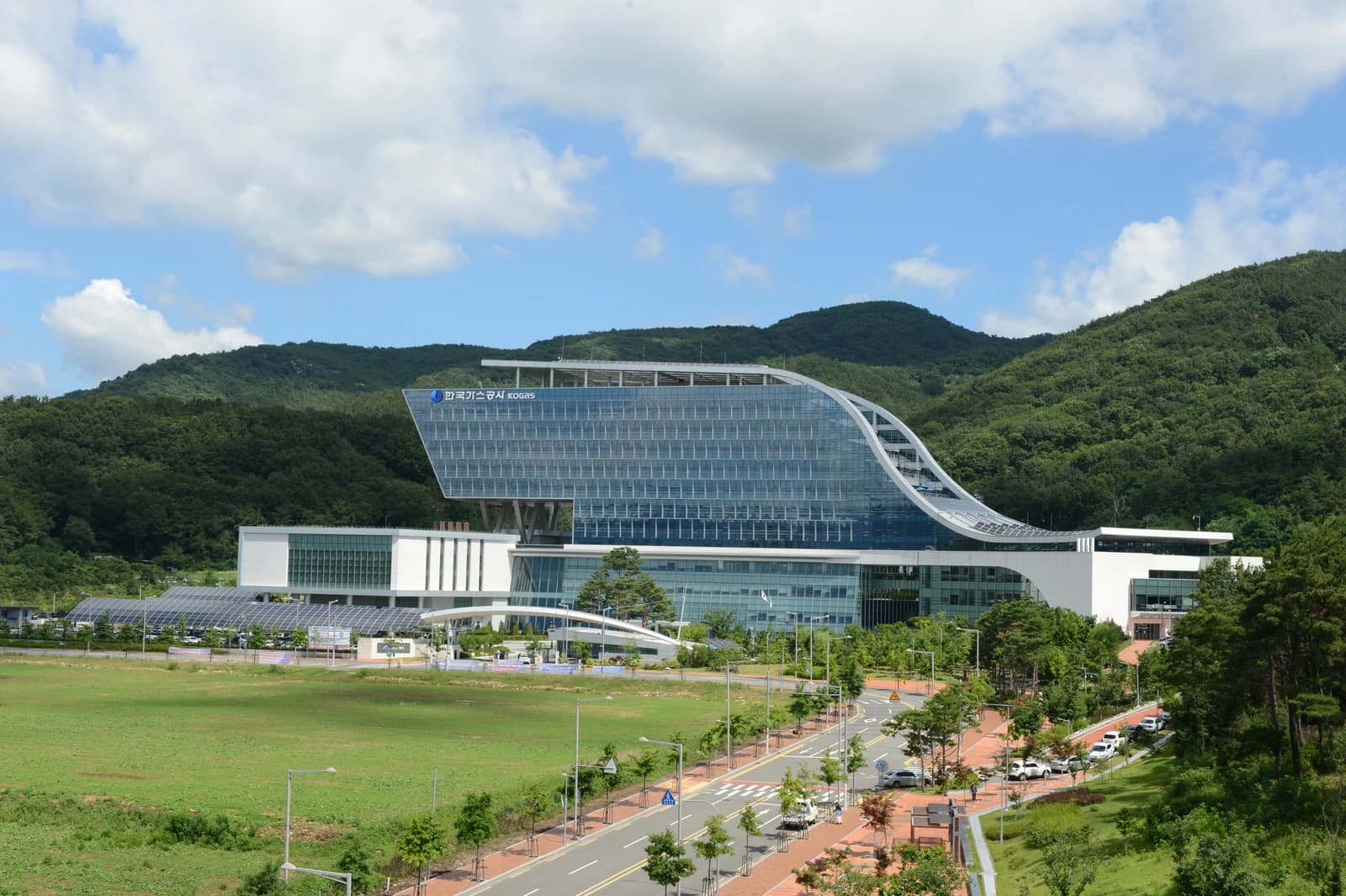 Exterior view of the Korea Gas Corporation (KOGAS) headquarters building with surrounding landscape.