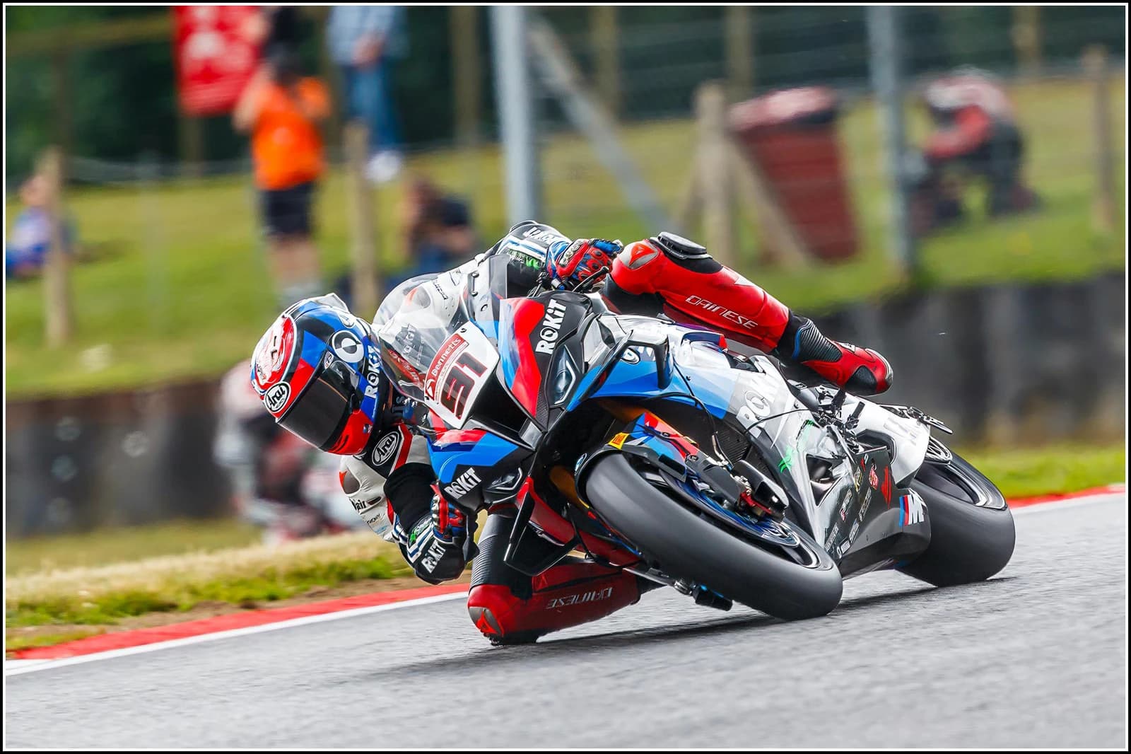 Leon Haslam, a superbike racer, corners his BMW Motorrad motorcycle on a track.