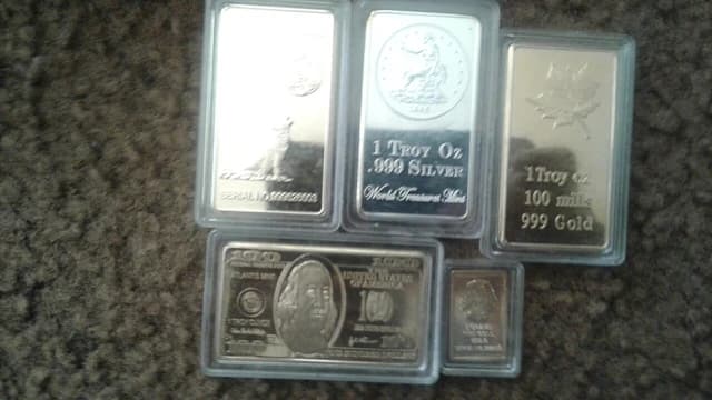 Gold and silver bars and rounds in clear protective cases.