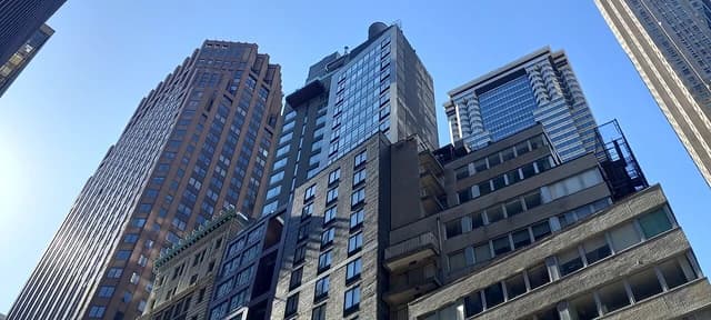 Skyscrapers in Manhattan's Financial District seen from a low angle on a clear day.