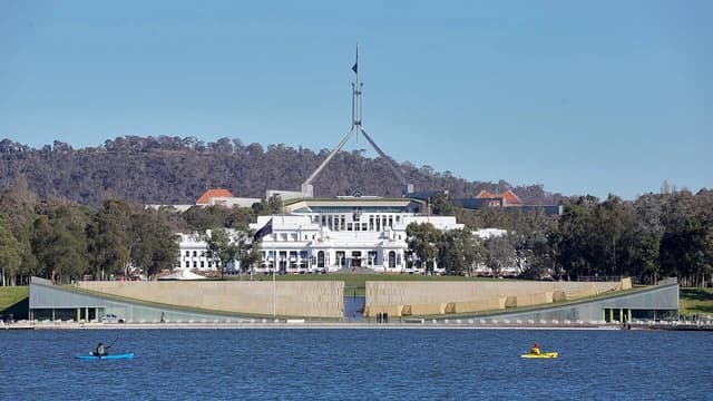 Australia's Old Parliament House and New Parliament House visible from across a lake.