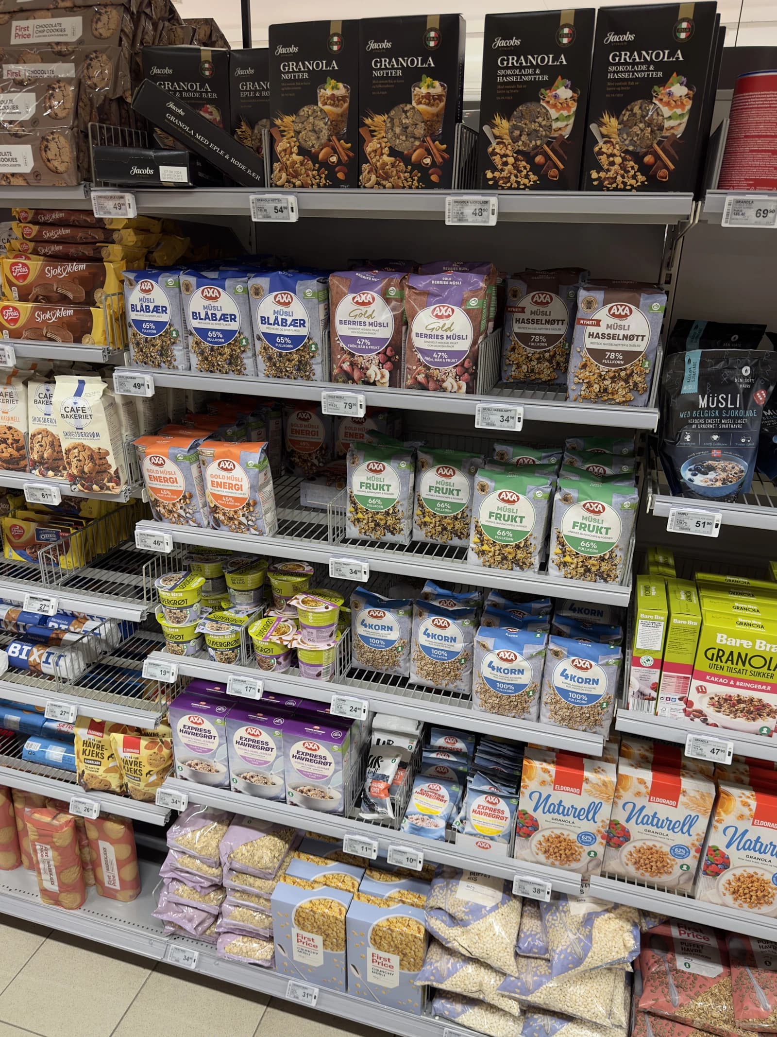 Supermarket aisle shelves displaying various brands of cereals, oatmeal, and biscuits.